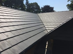 Newly completed dark grey tiled roof with a valley