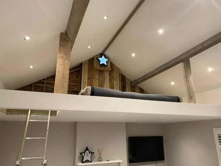 Loft conversion with exposed beams and a fitted loft ladder